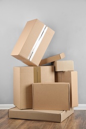 Pile of cardboard boxes near light blue wall indoors