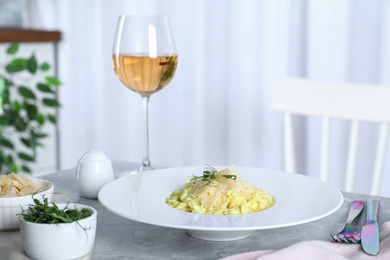 Photo of Delicious risotto with cheese on grey marble table indoors