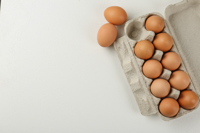 Photo of Raw chicken eggs on white table, flat lay. Space for text