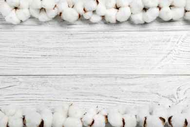 Flat lay composition with cotton flowers on white wooden background. Space for text