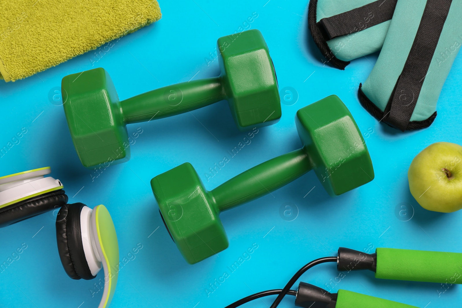 Photo of Flat lay composition with dumbbells on light blue background