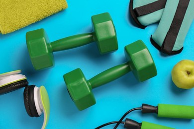 Flat lay composition with dumbbells on light blue background