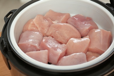 Photo of Fresh cut chicken in modern multi cooker, closeup