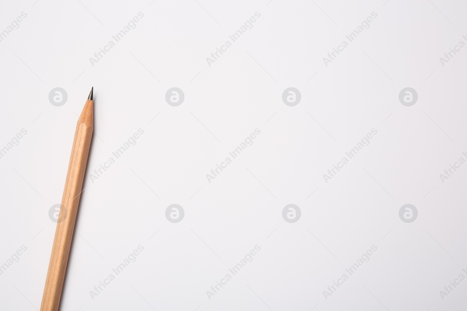 Photo of Sharp graphite pencil on white background, top view. Space for text