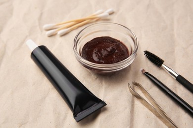 Photo of Eyebrow henna and tools on crumpled paper, closeup