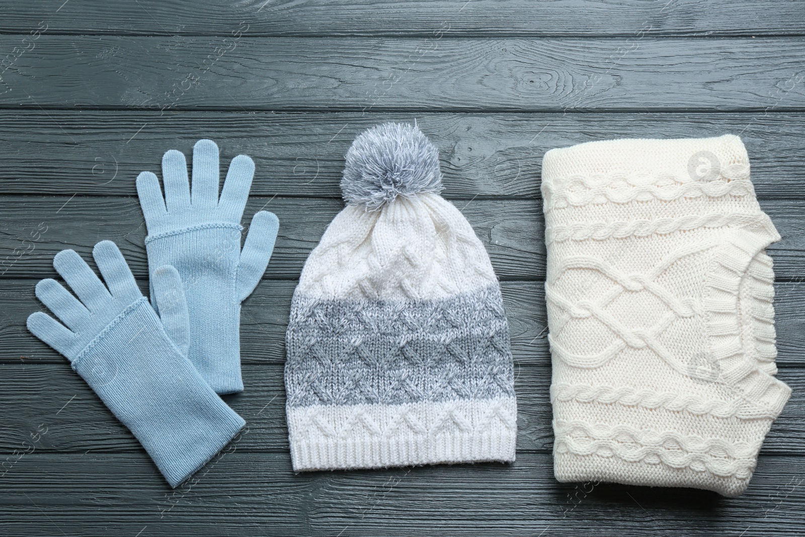 Photo of Flat lay composition with warm clothes on dark wooden background