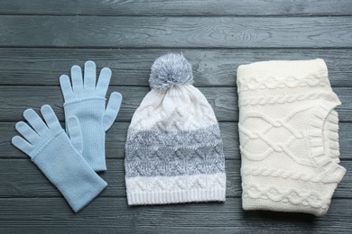 Photo of Flat lay composition with warm clothes on dark wooden background