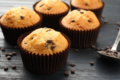 Delicious freshly baked muffins with chocolate chips on dark gray table, closeup