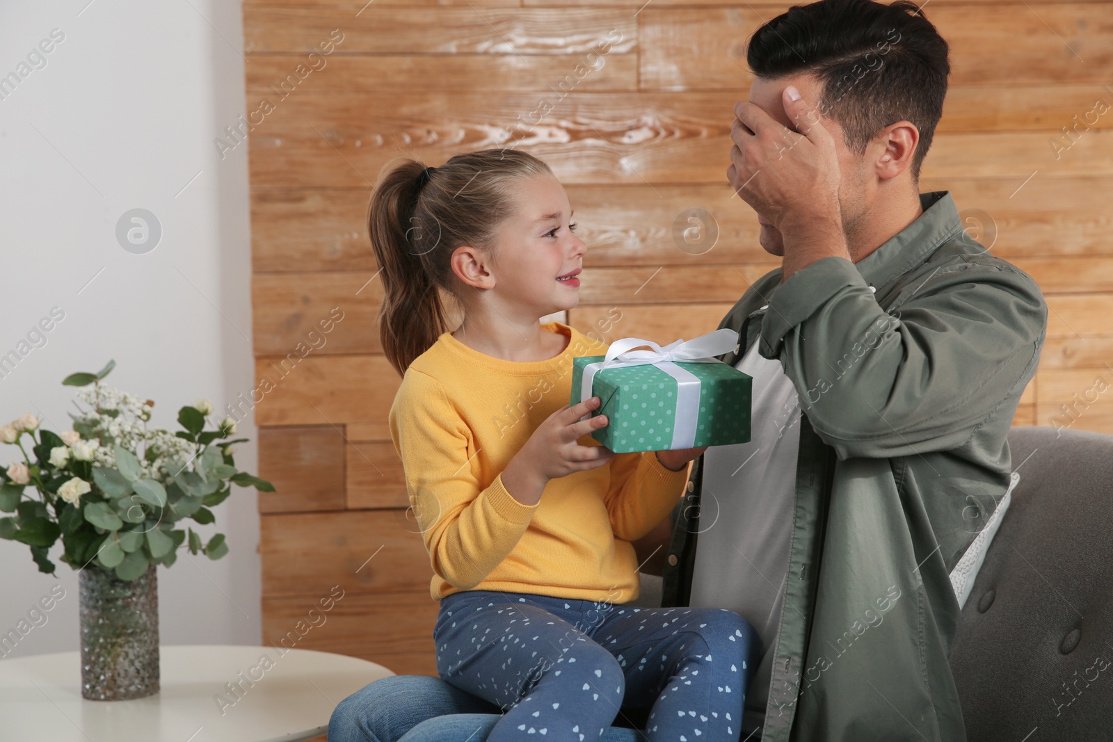 Photo of Man receiving gift for Father's Day from his daughter at home