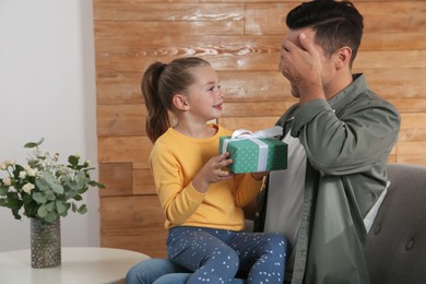Photo of Man receiving gift for Father's Day from his daughter at home