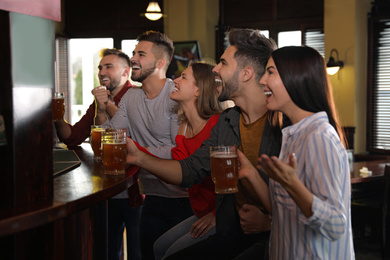 Group of friends watching football in sport bar