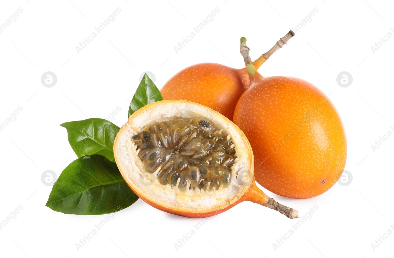 Photo of Whole and cut delicious ripe granadillas with green leaves on white background