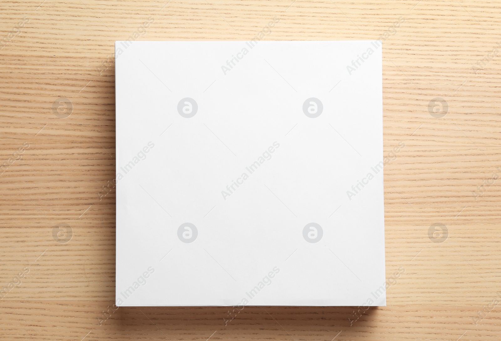 Photo of Stack of blank paper sheets for brochure on wooden background, top view. Mock up