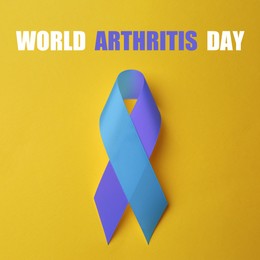 World Arthritis Day. Blue and purple awareness ribbon on yellow background, top view