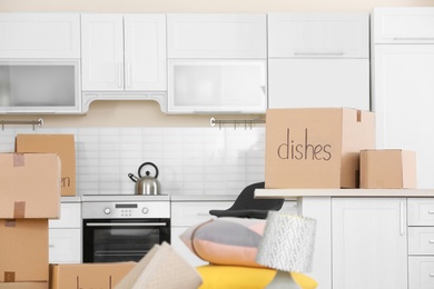 Photo of Cardboard boxes and household stuff in kitchen. Moving day