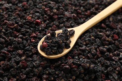 Photo of Spoon and tasty dried currants as background, closeup