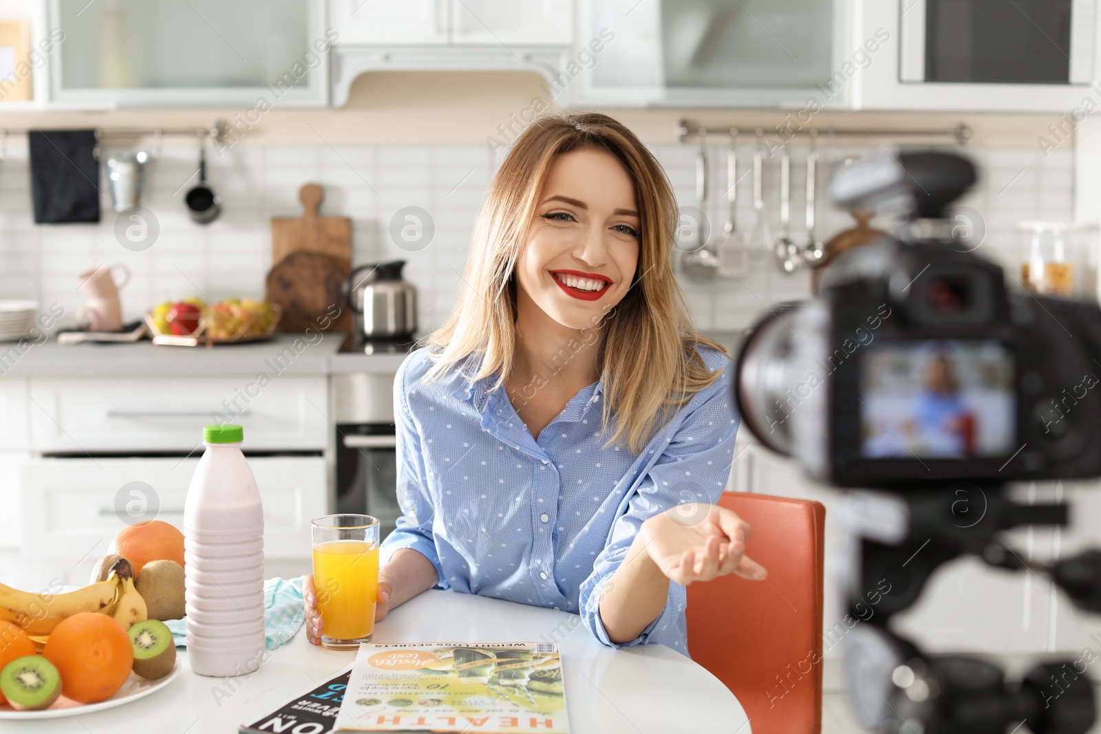 Photo of Food blogger recording video on camera in kitchen