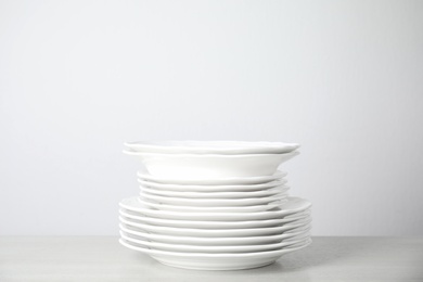 Stack of clean plates on table against white background. Space for text