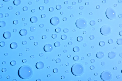 Photo of Water drops on color background, top view