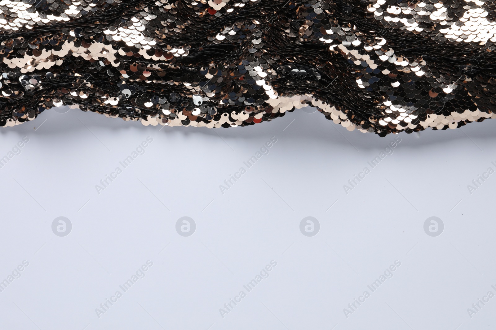Photo of Beautiful golden sequin fabric on white background. Space for text