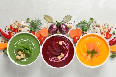 Photo of Various cream soups and ingredients on grey background, flat lay. Healthy food