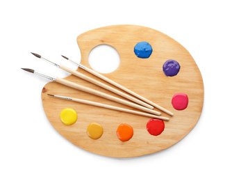Photo of Palette with paints and brushes on white background, top view