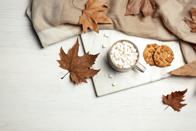 Photo of Flat lay composition with hot cozy drink and autumn leaves on wooden background