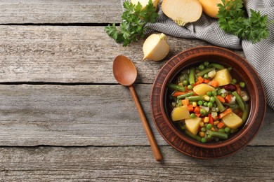 Photo of Bowl of delicious turnip soup served on wooden table, flat lay. Space for text