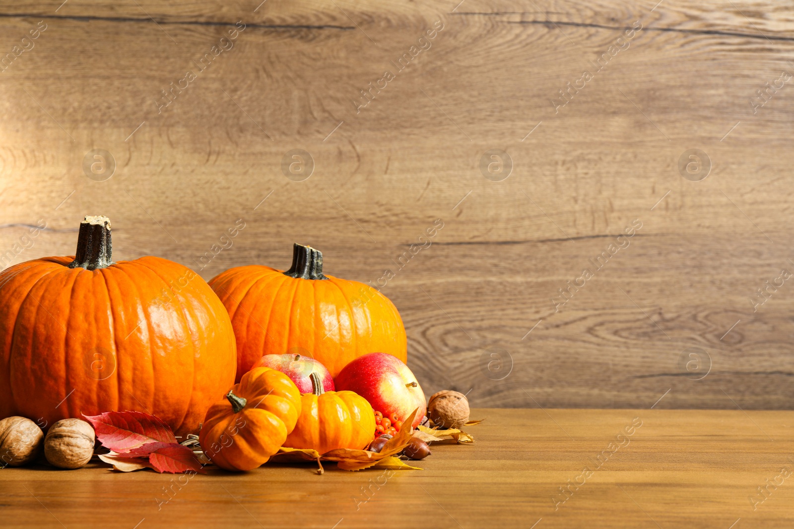 Photo of Composition with ripe pumpkins and autumn leaves on wooden table, space for text. Happy Thanksgiving day