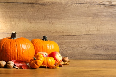 Composition with ripe pumpkins and autumn leaves on wooden table, space for text. Happy Thanksgiving day