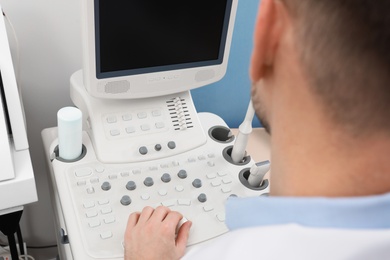 Sonographer operating modern ultrasound machine in clinic, closeup