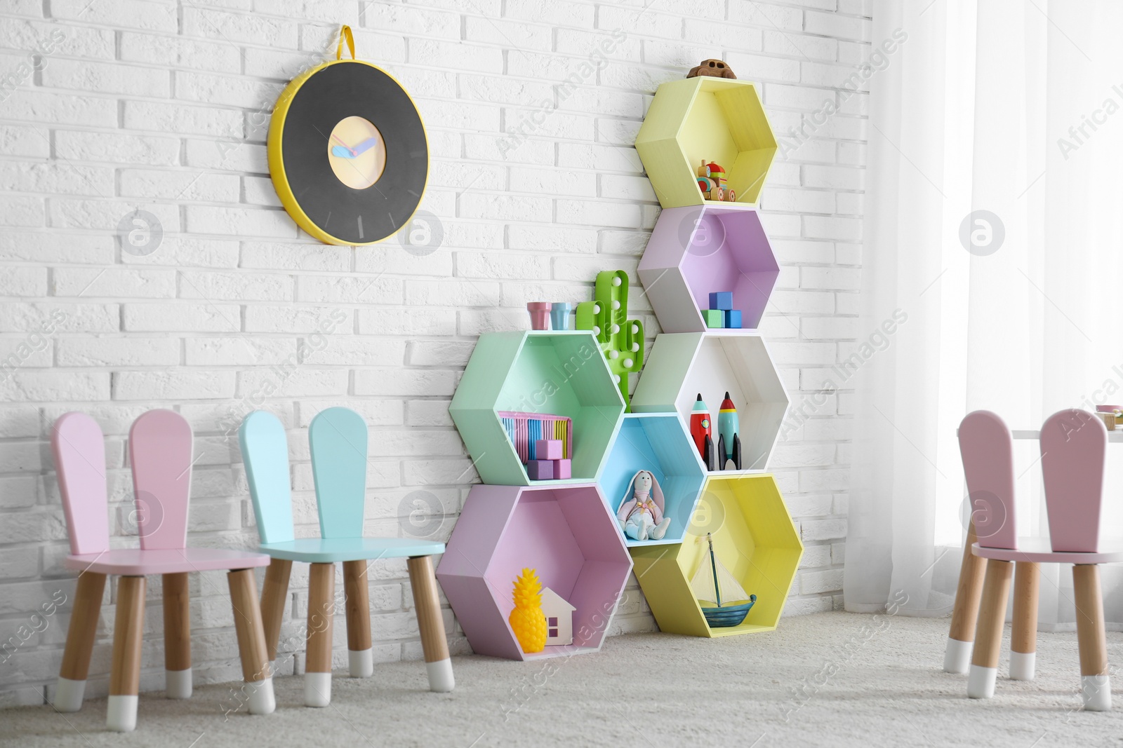 Photo of Child room interior with colorful shelves near brick wall