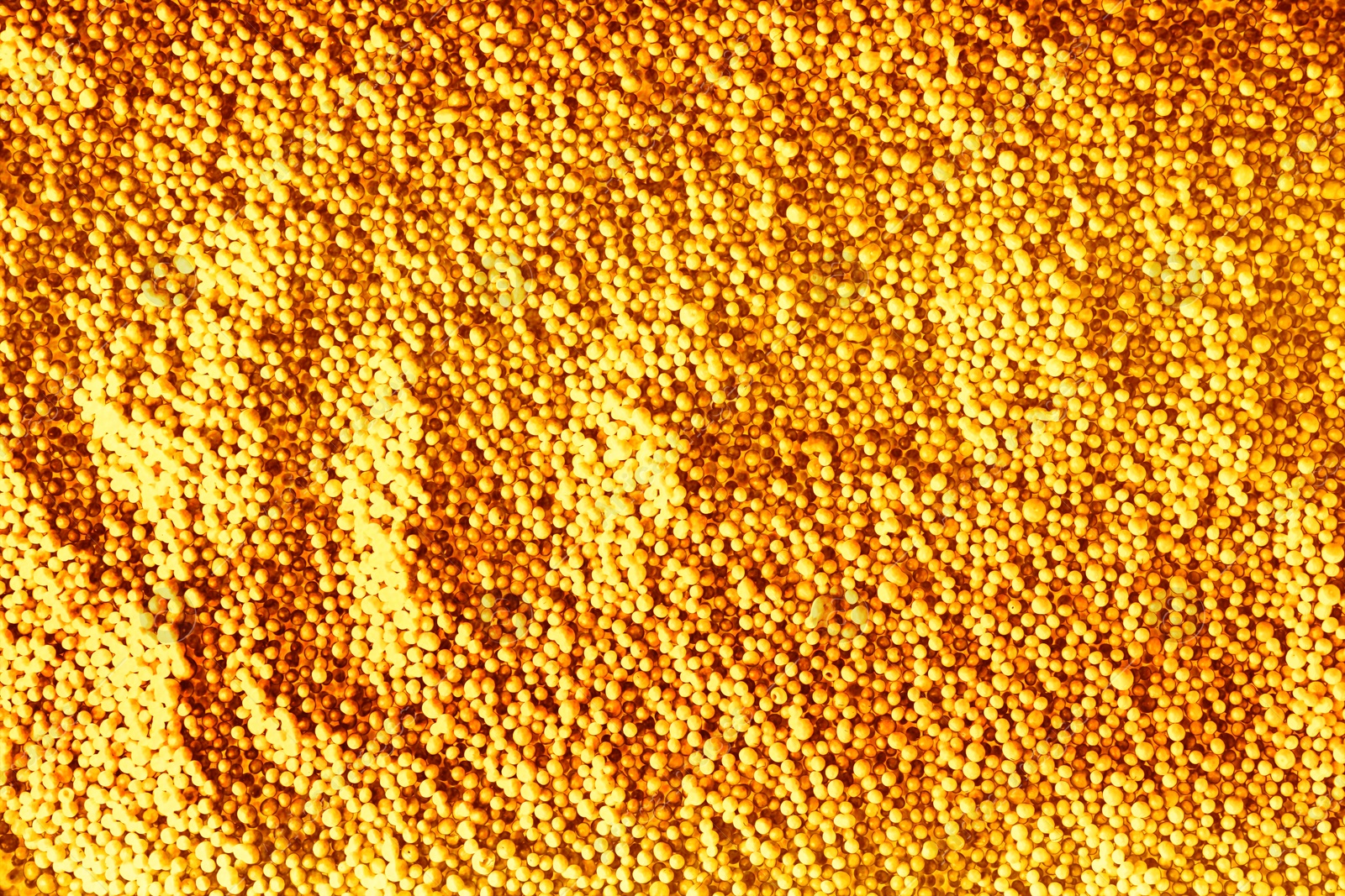 Image of Many golden beads as background, top view