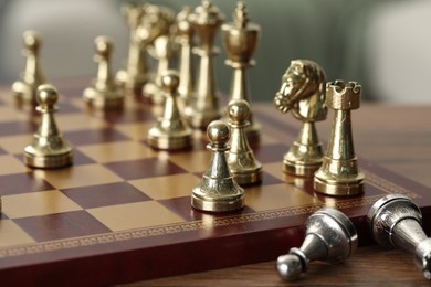 Chess board with pieces on wooden table, selective focus. Space for text