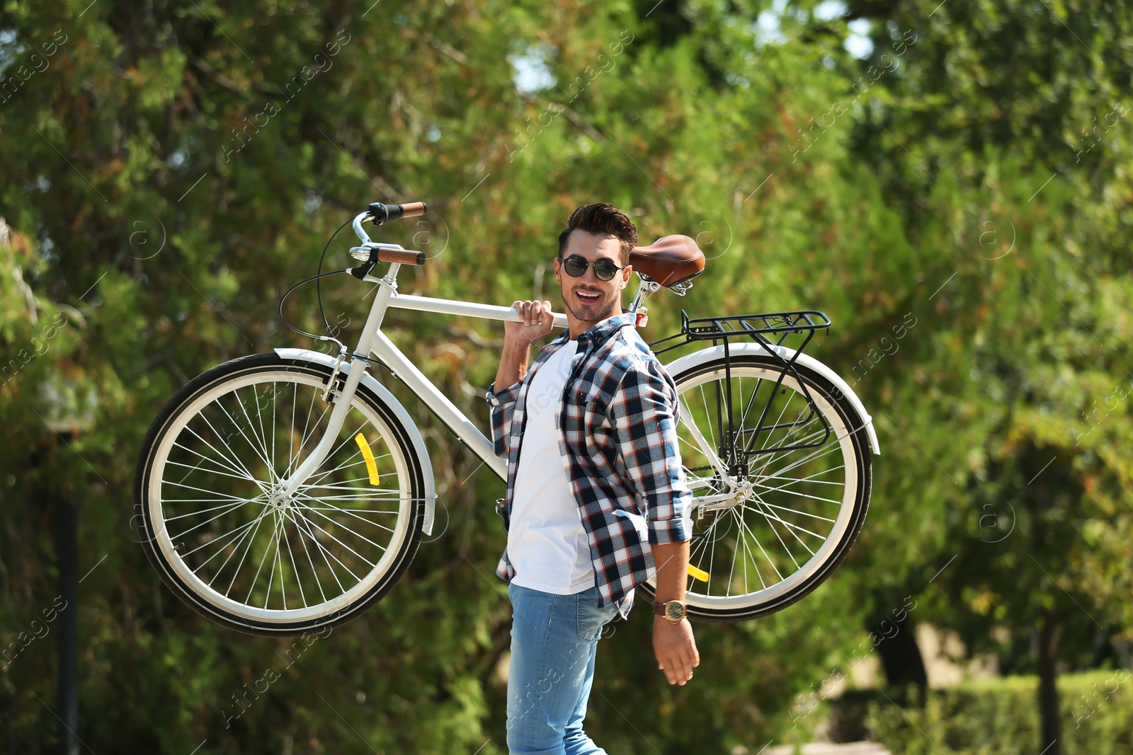 Photo of Handsome young hipster man with bicycle in park