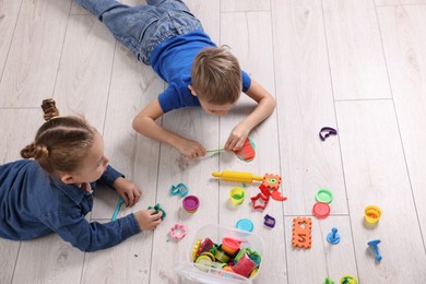 Photo of Cute little children playing on warm floor indoors, space for text. Heating system