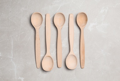 Wooden spoons on grey table, flat lay. Cooking utensils