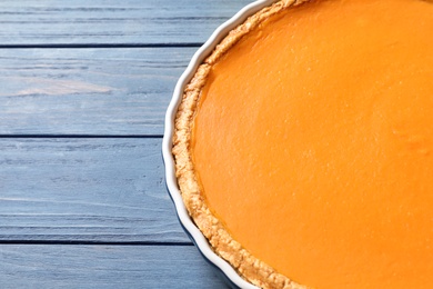 Photo of Fresh delicious homemade pumpkin pie and space for text on wooden background