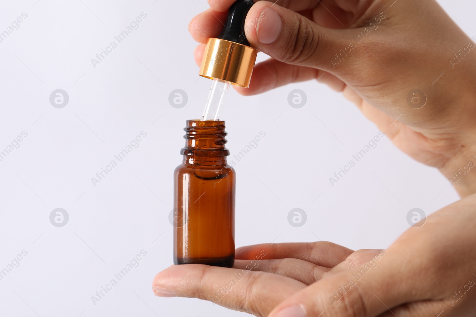 Photo of Woman with bottle of cosmetic serum and dropper on white background, closeup