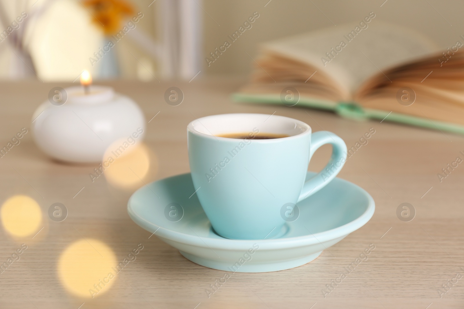 Photo of Cup of aromatic coffee on wooden table indoors. Bokeh effect