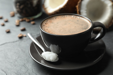 Photo of Delicious coffee with organic coconut oil on grey table