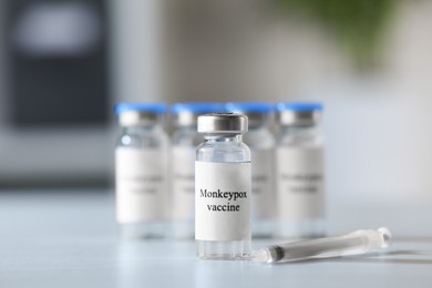 Monkeypox vaccine in vials and syringe on white table