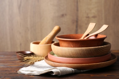 Different dishware on wooden table, space for text