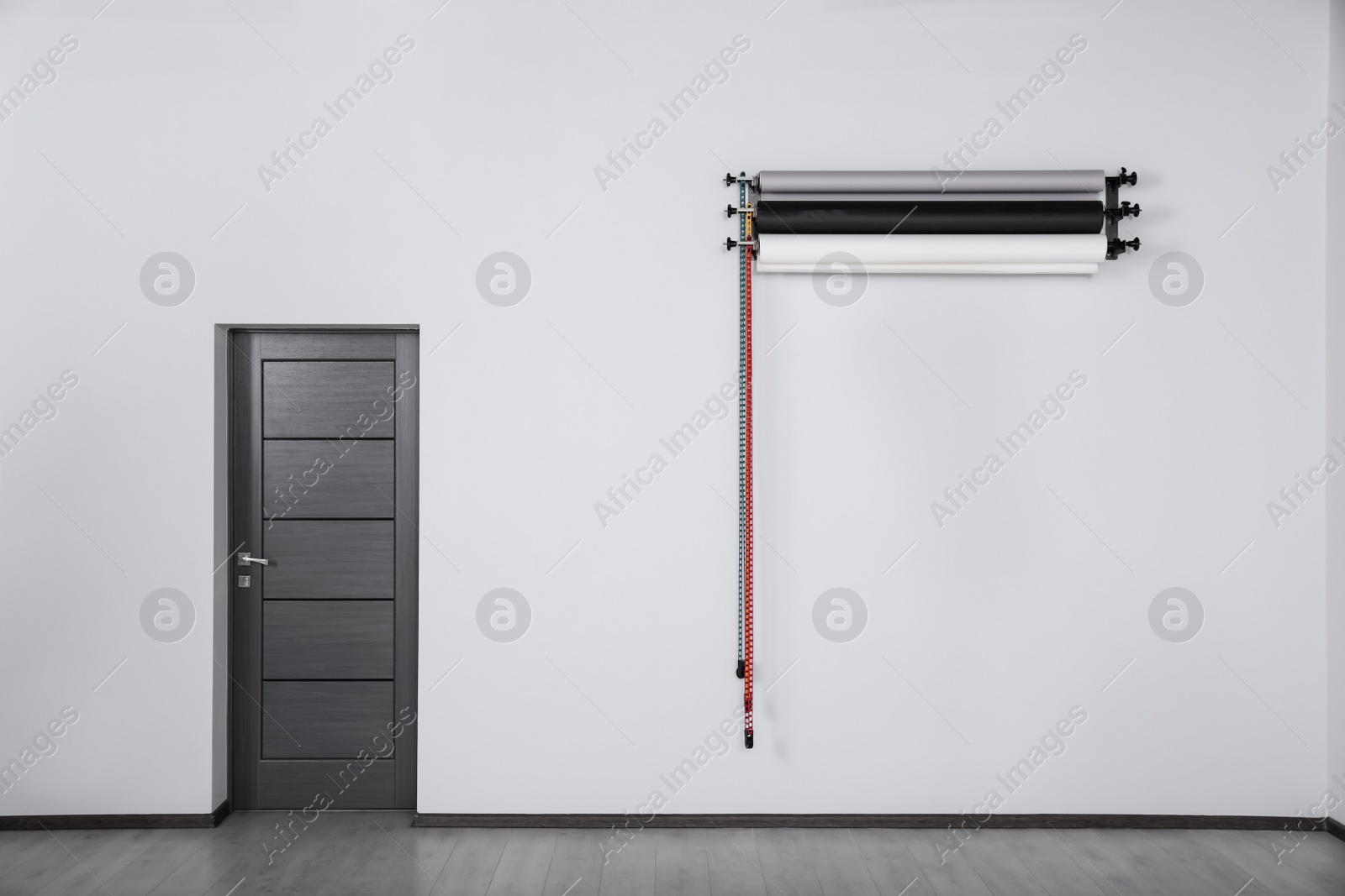 Photo of Colorful photo background rolls near door in office. Interior design