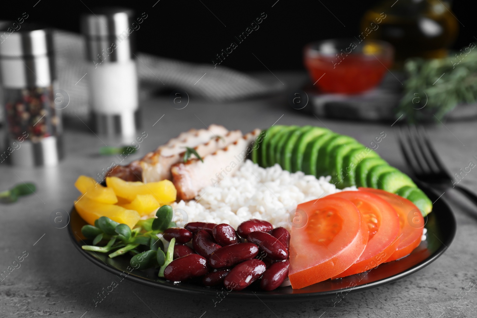 Photo of Delicious rice with beans served on grey table, closeup