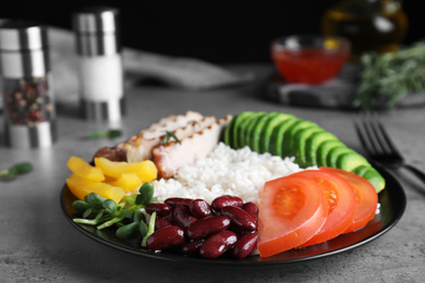 Photo of Delicious rice with beans served on grey table, closeup