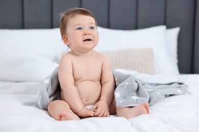 Photo of Cute baby boy sitting on bed at home