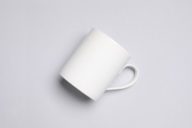 Photo of One white ceramic mug on light background, top view