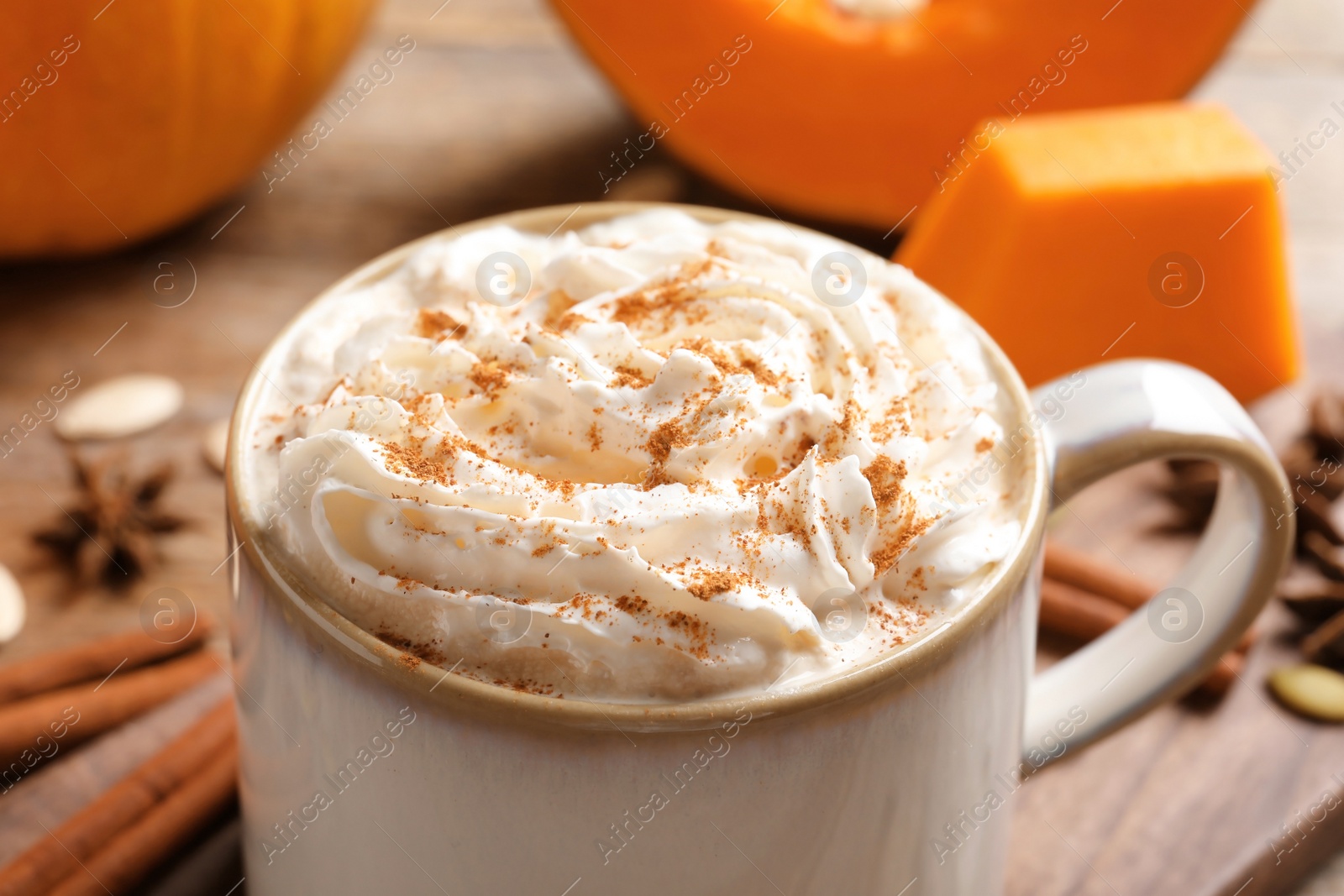 Photo of Cup with tasty pumpkin spice latte on table, closeup