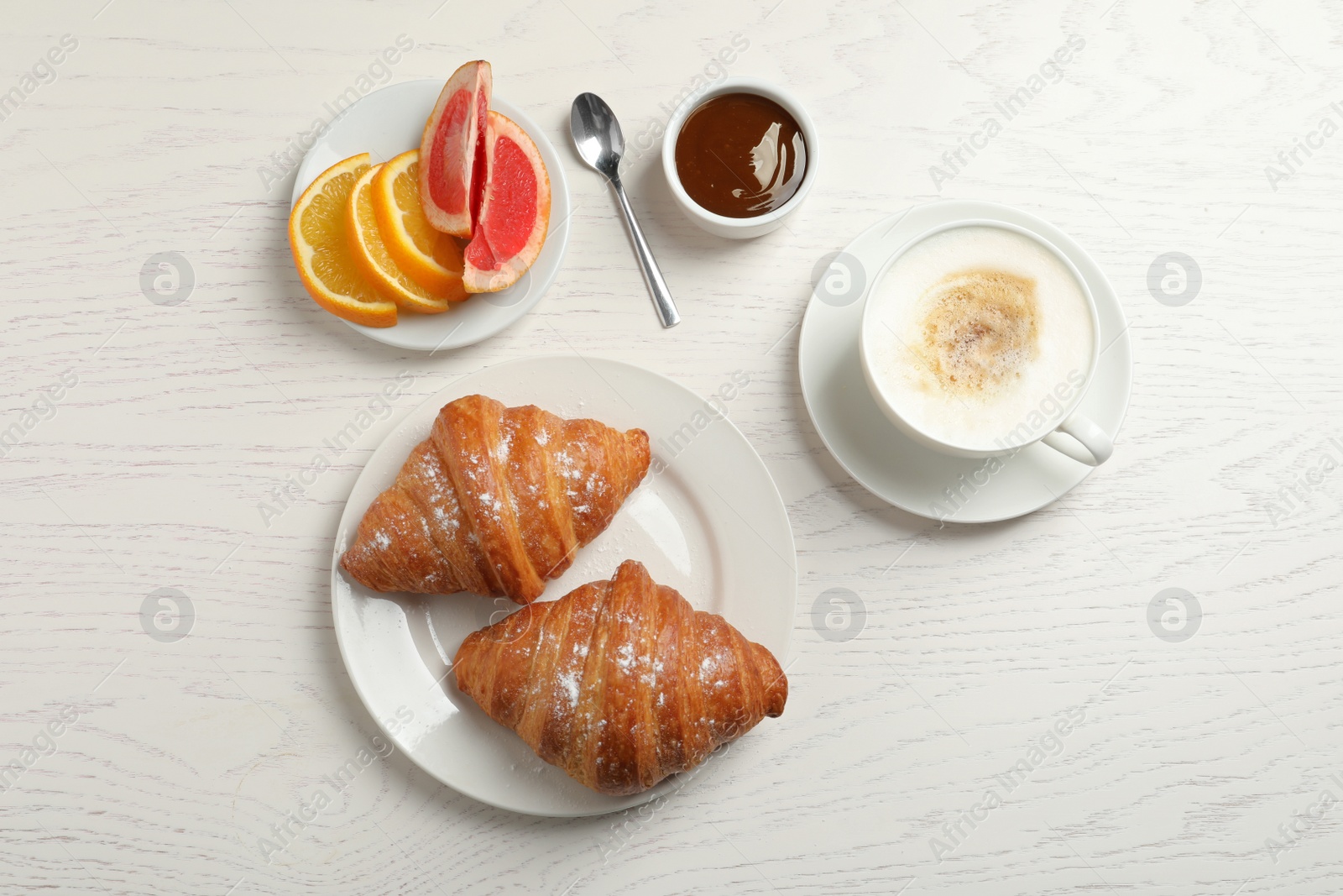 Photo of Tasty breakfast served on white wooden table, flat lay